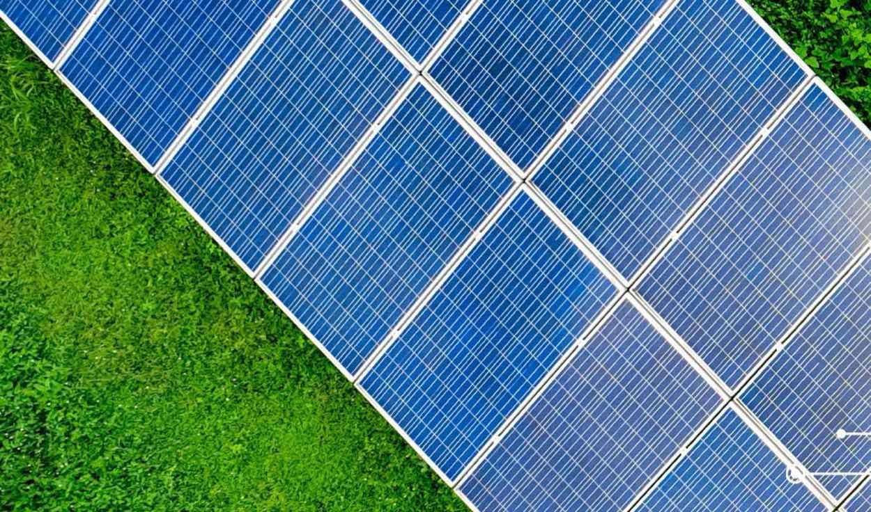 Vista aérea de fileiras de painéis solares sobre gramado